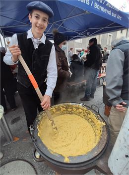 Un bénévole brasse la polenta dans un chaudron - A.Lombard - OTHMV