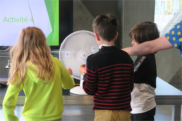 3 enfants testant leur éolienne devant un ventilateur - La Turbine sciences