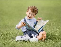petit garçon qui lit dans un pré - Pixabay