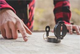 Photo d'une personne regardant une carte avec une boussole - Image de Freepik
