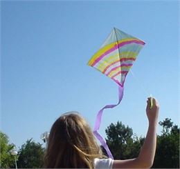 Fillette faisant voller un cerf-volant muticolor - Emmanuel Bacharach - Les Arts Volants