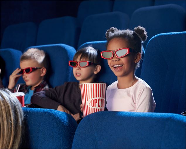3 enfants dans une salle de cinéma - SerhiiBobyk