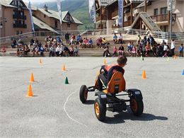 enfant faisant du kart à pédale sur une place - Ot-Valmienier