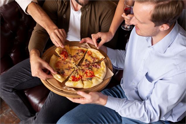 hommes qui mangent de la pizza - freepik