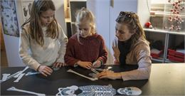 Une mère avec ses filles devant un squelette en papier - Quentin Trillot - Ville d'Annecy