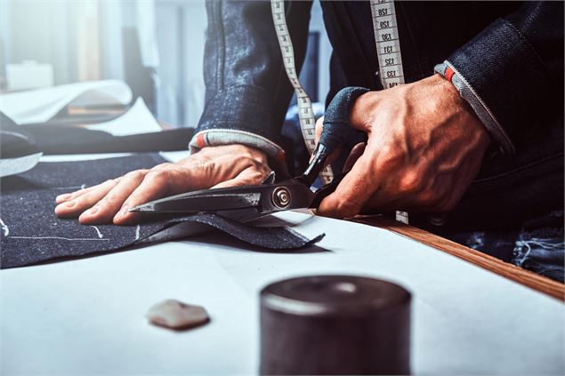 Découpe de tissu avec une paire de ciseaux. - Freepik