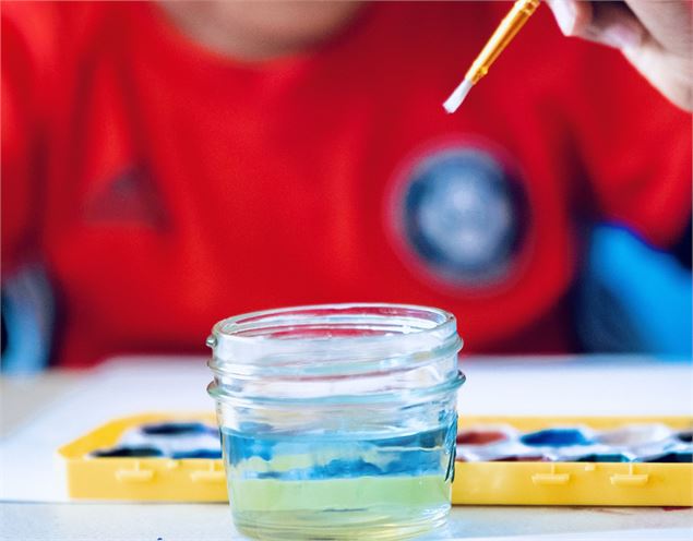 enfant tenant un pinceau devant un pot d'eau et une palette de peinture - pixabay Enson Renton