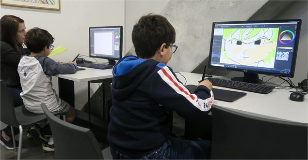 Un enfant s'applique à dessiner sur PC - La Turbine sciences