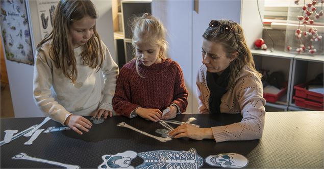 Une mère avec ses filles devant un squelette en papier - Quentin Trillot - Ville d'Annecy