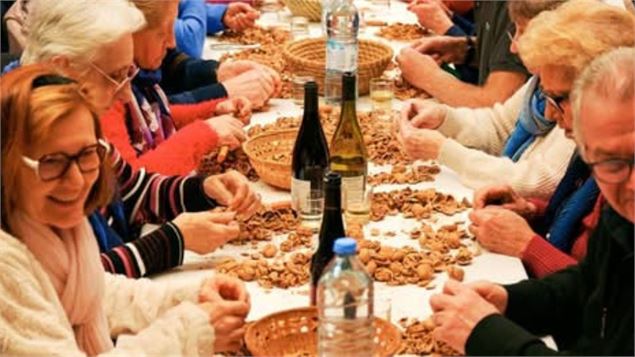 personnes assises à table cassants des noix - OT RUMILLY