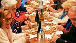 personnes assises à table cassants des noix - OT RUMILLY