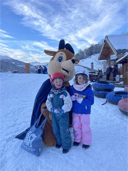 une mascotte qui prends une photo avec des enfans - OT - Valmeinier