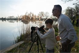 Un père et son fils regardent les oiseaux à travers une longue vue - Corinne Bertrand