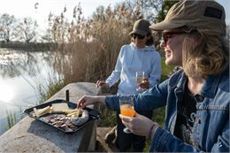Des participants dégustent un apéritif au bord d'un étang - Corinne Bertrand