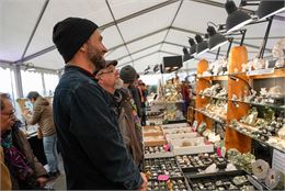Un homme devant un étal de minéraux - Cristal Source