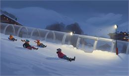 Quatre personnes dévalent une piste de luge enneigée en soirée. À droite, la piste est éclairée par 