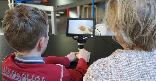 Un enfant et sa grand-mère devant un microscope - La Turbine sciences