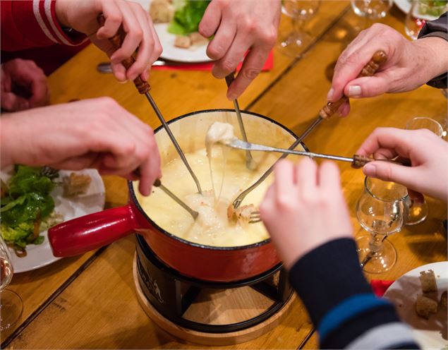 fondue avec les mains autour et les pics dans le fromage fondu - Pixabay