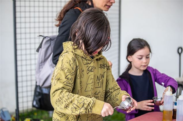 Une jeune fille en train de mélanger des plantes dans un pilon - JyHell