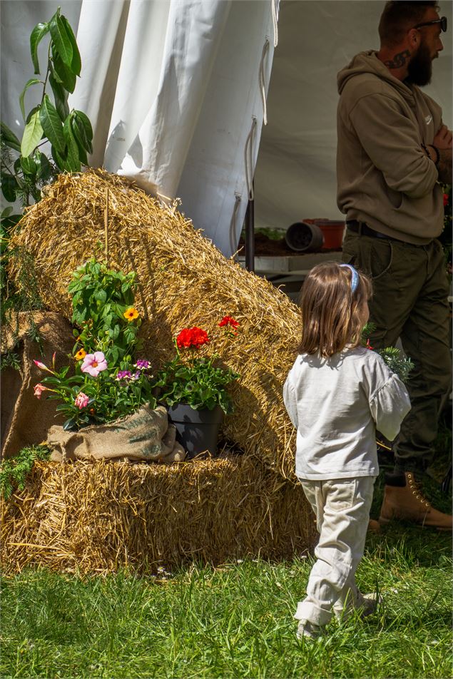 Une petite fille de dos, devant une botte de paille - Marion TODESCHINI