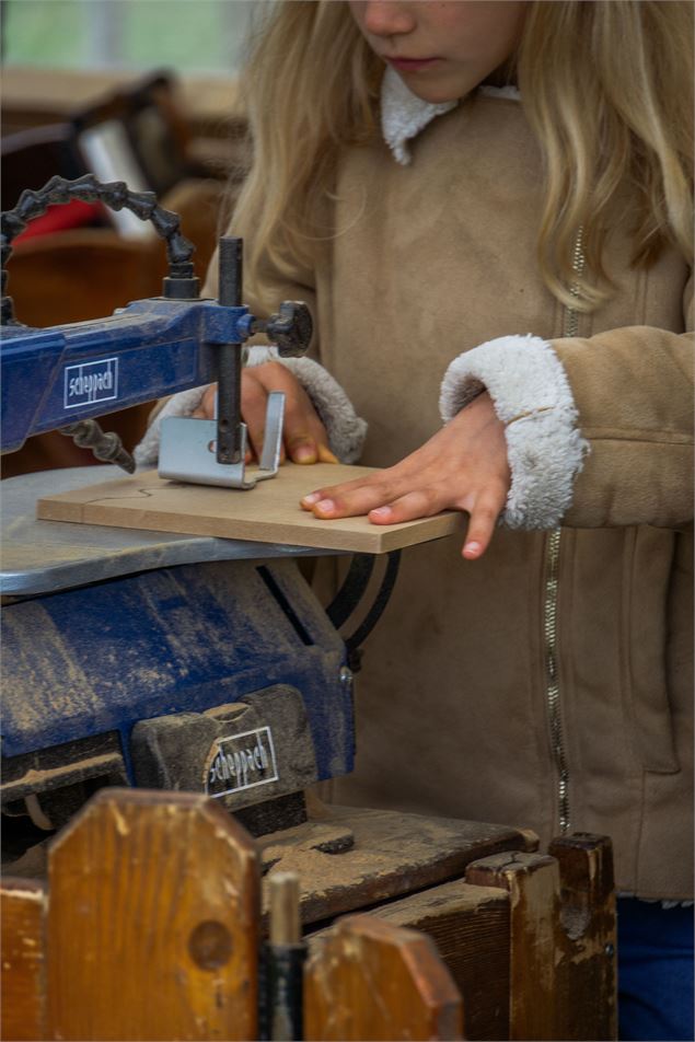Une petite fille manie une scie sauteuse - Marion TODESCHINI