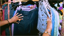 personne qui cherche des habits dans une friperie - canva