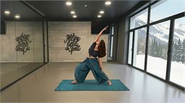 Une pratiquante de yoga fait une posture de la danse du dragon en solo face aux montagnes enneigées 