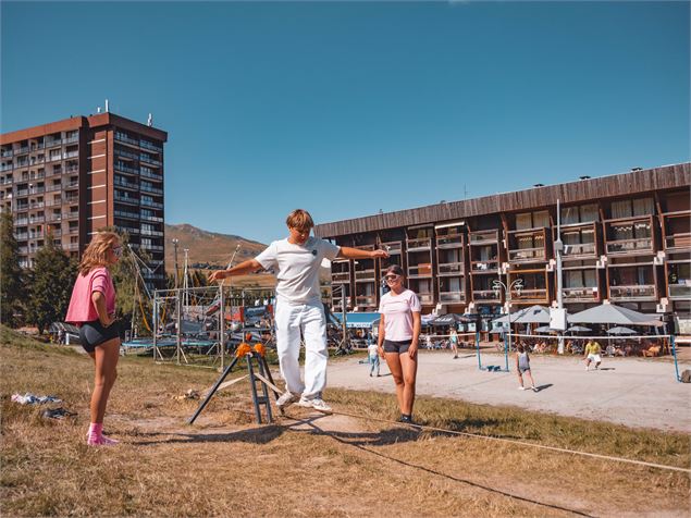 Ados qui s'initient à la slackline en centre station du Corbier - Office de Tourisme Le Corbier