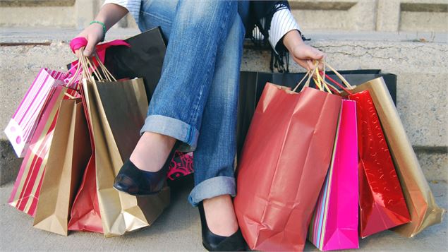 mains de femmes avec plusieurs sacs de shopping des deux côtés - canva