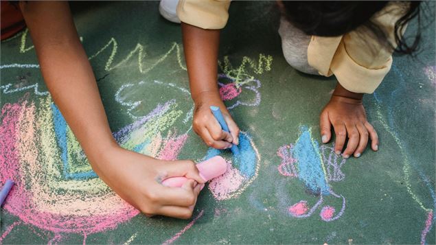 enfants qui écrivent à la craie par terre - canva