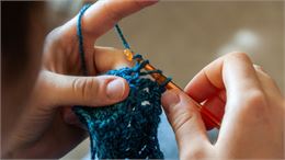 main de femme en train de faire du crochet - canva