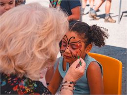 Petite fille qui se fait maquiller par notre animatrice au Corbier - Office de Tourisme Le Corbier
