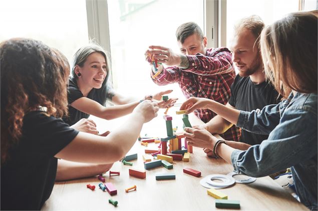 Un groupe d'amis créatifs assis sur une table en bois - Freepik