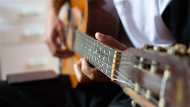 homme qui fait de la guitare - canva