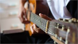 homme qui fait de la guitare - canva