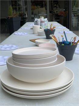 Table remplie d'assiettes non peintes, avec matériels de peinture - DR / La Petite Livrerie