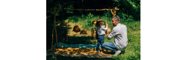 Un enfant joue avec les calebasse accompagné d'un adulte - Collectif La Curieuse