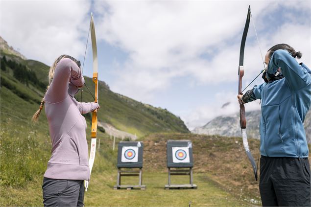Femme et homme qui font du tir à l'arc à Val d'Isère - Tristan Shu