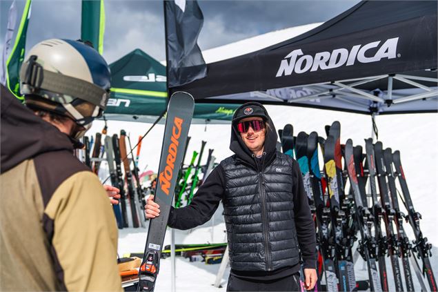 Un skiman tend une paire de ski à un participant - OTHMV