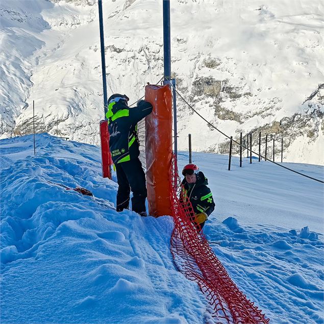 Deux pisteurs rattachent des matelas de protection - Pisteurs de Bonneval sur Arc