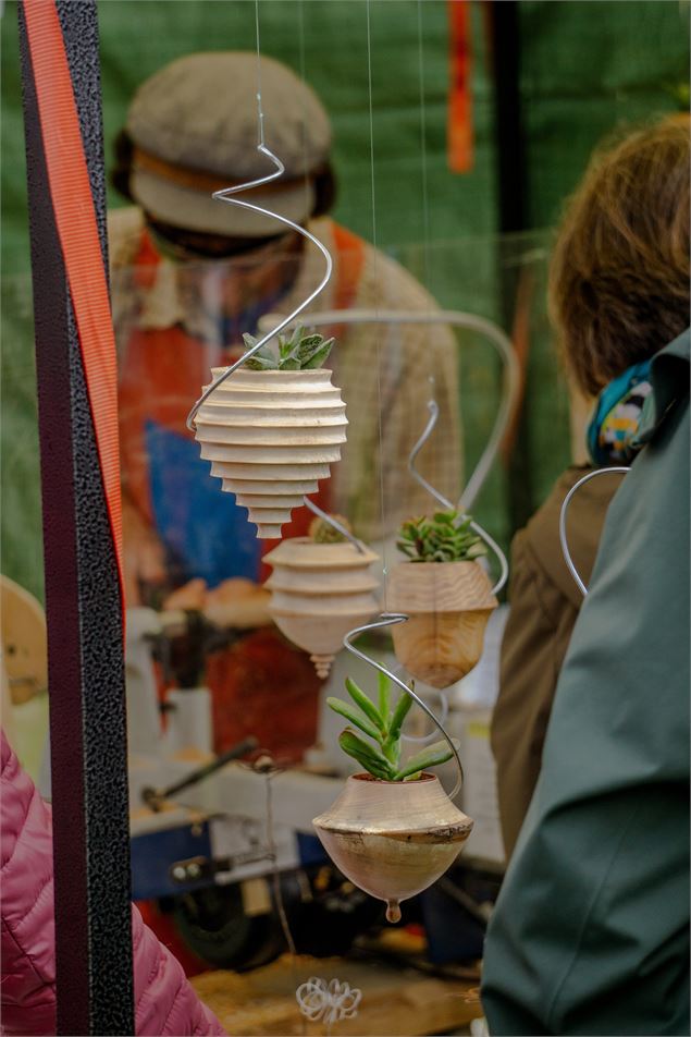 Un artisan vend des pots de fleurs en bois sculpté - Marion TODESCHINI