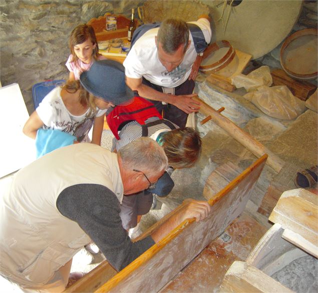 Un groupe fabrique de la farine - Association les Moulins de Pralognan de Saint André
