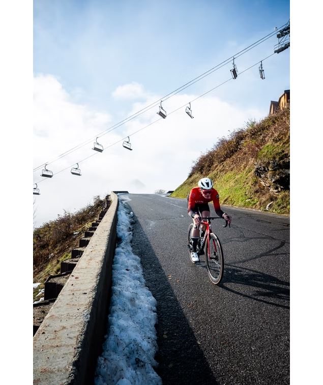 Cycliste à la montagne avec des télécabines en fond - Baroudeurs des Alpes