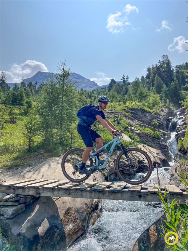 Un cycliste traverse un ruisseau sur une passerelle - LVO