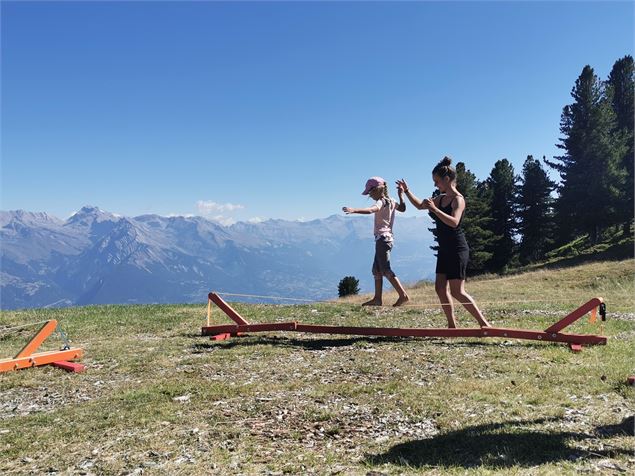 Une petite fille s'initie sur une petite slackline - Alexis bg timide