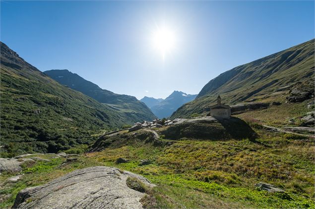 Vue sur le hameau de l'ecot et sa chapelle sous le soleil à son zenith entre les montagnes - CCHMV