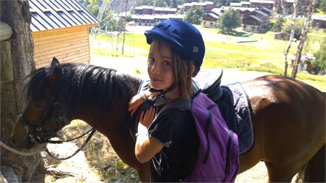 Une fillette selle un poney - OT La Norma