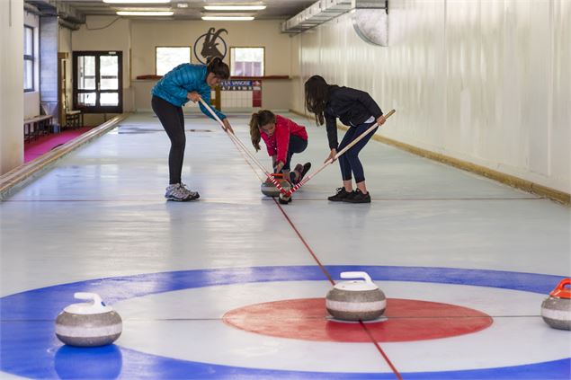 Amis en train de s'essayer au curling - Gilles Lansard