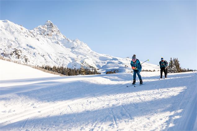 Ski de fond sur les pistes ensoleillées de Méribel Altiport avec vue sur les montagnes. - Sylvain Ay