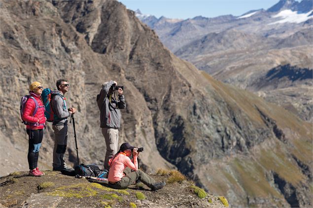 Groupe de randonneurs qui font des photos depuis l'alpage de Tovière - Val d'Isère Tourisme